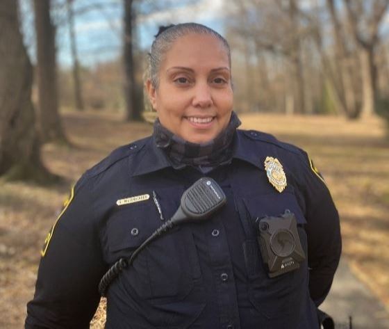 Photo of Cpl. Miltenberger standing in the park in her town police uniform